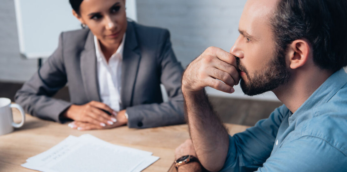 A man sitting at a table seeking legal advice from a criminal lawyer.