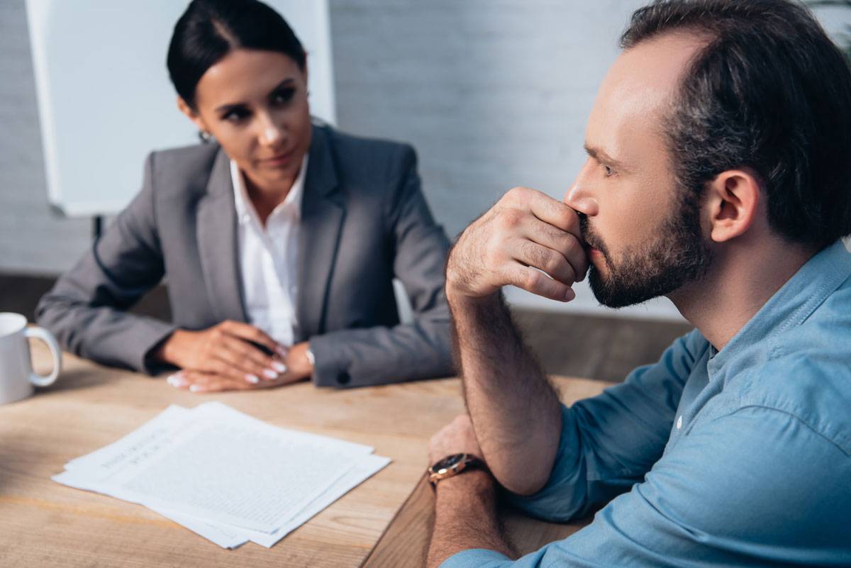 A man sitting at a table seeking legal advice from a criminal lawyer.