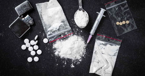 Un assortiment de drogues sur une table, suggérant la nécessité d'un avocat criminel en cas d'arrestation drogue.