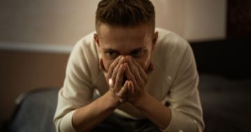 A distraught man facing assault charges in need of a criminal lawyer.